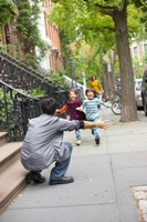 Father's Day: two children running toward their dad, showing love and respect.