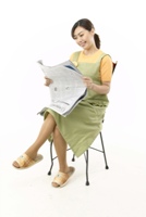 Good news? (Photo of a woman reading a newspaper and smiling.)