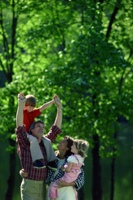 Photo of a loving, happy family walking in the woods, to illustrate God's loving family.