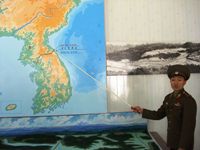 North Korean soldier pointing at the DMZ (photo by Kristoferb at en.wikipedia).