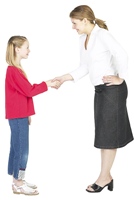 Polite girl shaking hands with a smiling woman.